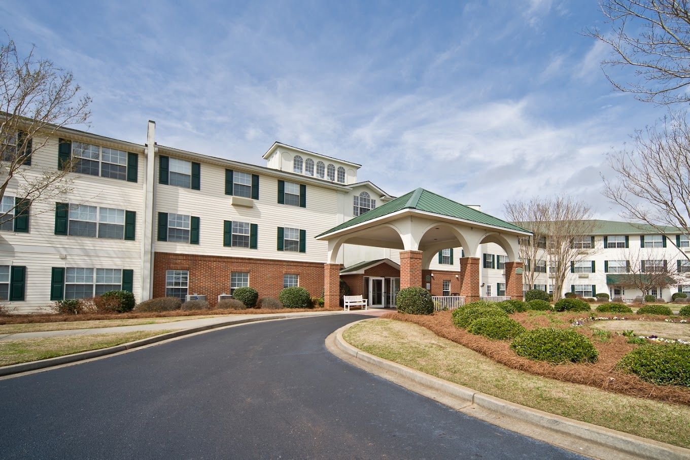 Front view of a senior living facility with landscape