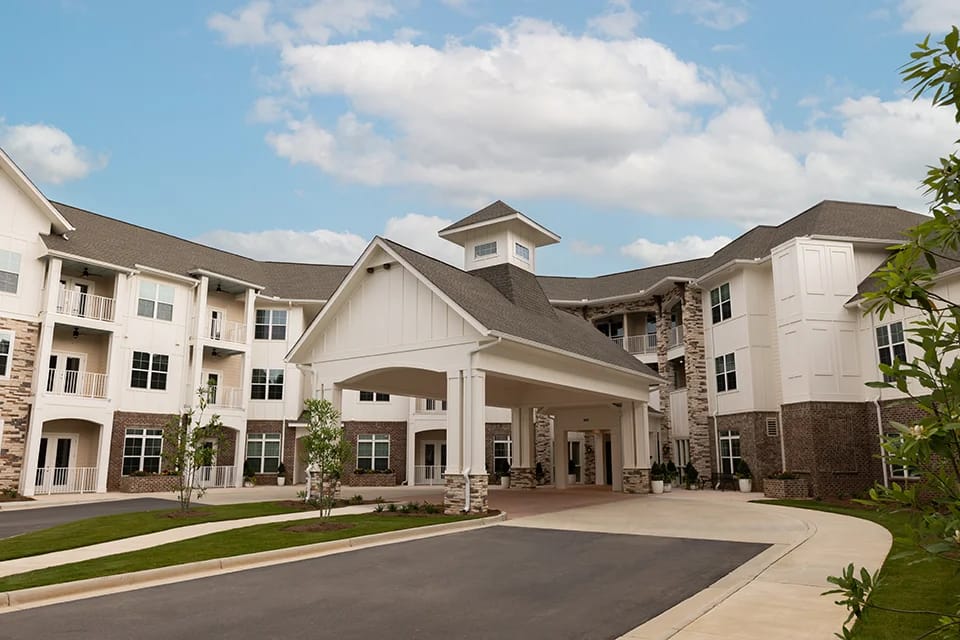 Exterior view of a senior living facility with a covered entrance