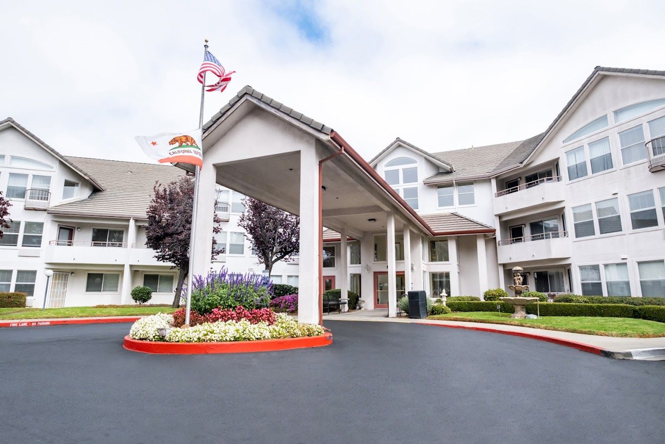 Entrance of Truewood by Merrill, Pinole with flowers and flags