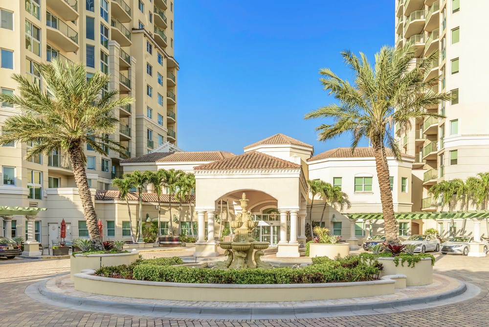 Exterior view of a senior living facility with palm trees