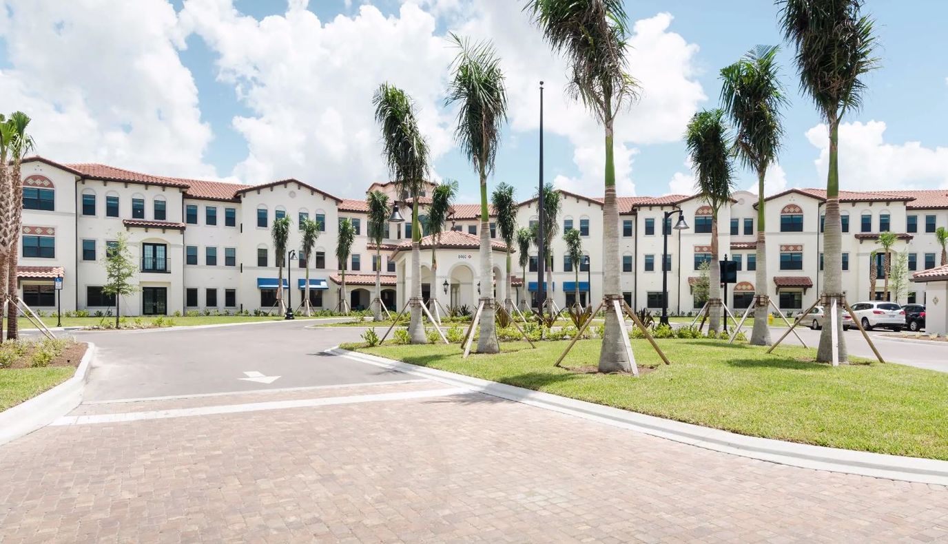 Exterior view of American House Coconut Point with palm trees
