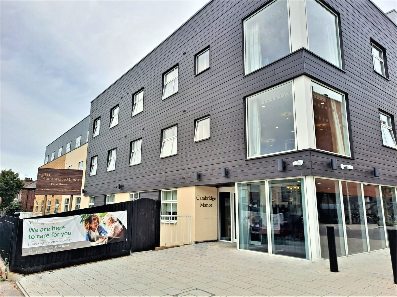 Exterior view of Cambridge Manor with signage