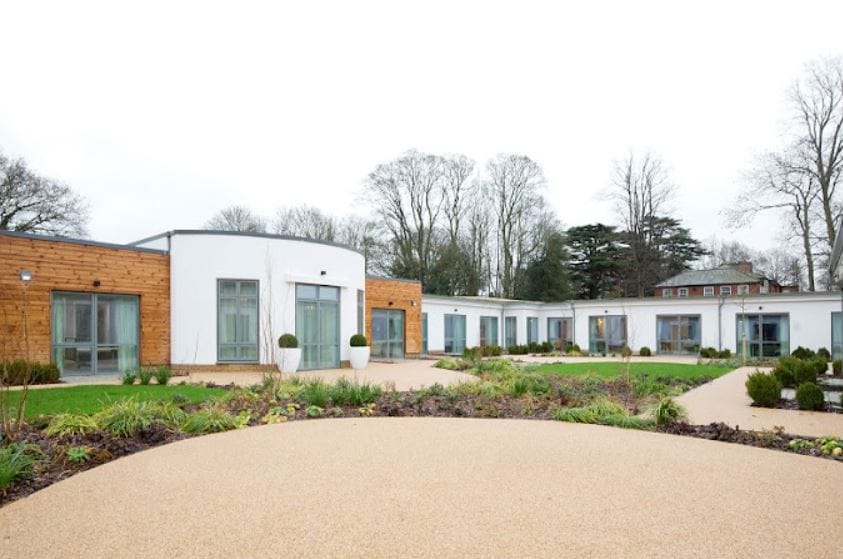 Exterior view of Clarendon Lodge Care Home with gardens