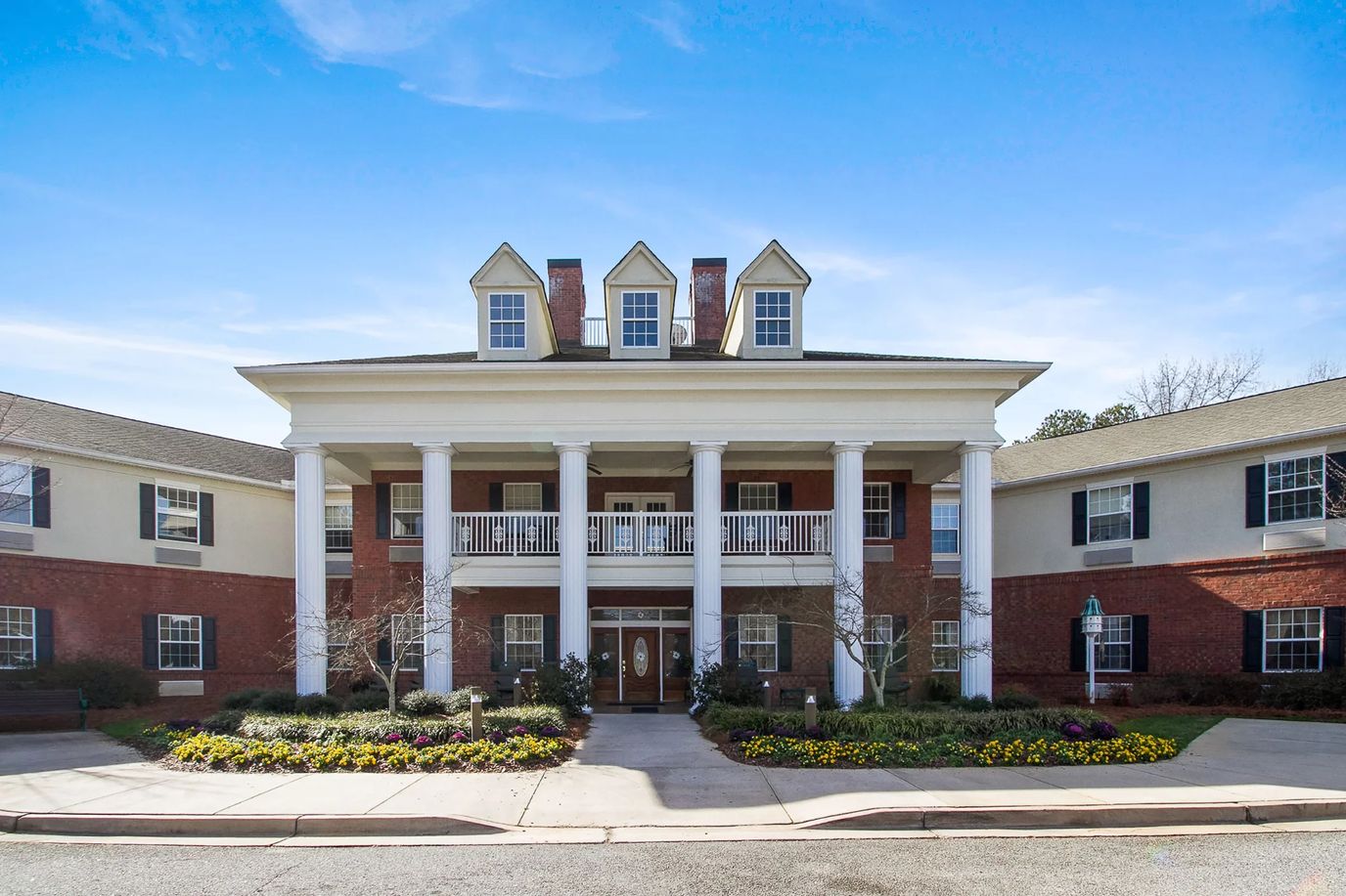 Exterior view of Oaks at Fayetteville with floral landscaping