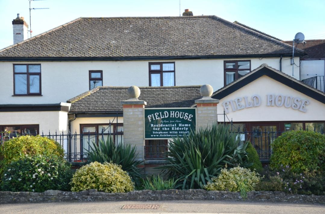 Exterior view of Field House Care Home with garden
