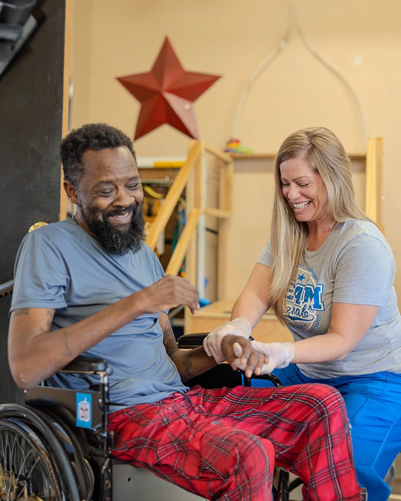 Staff assisting a resident in a cheerful environment