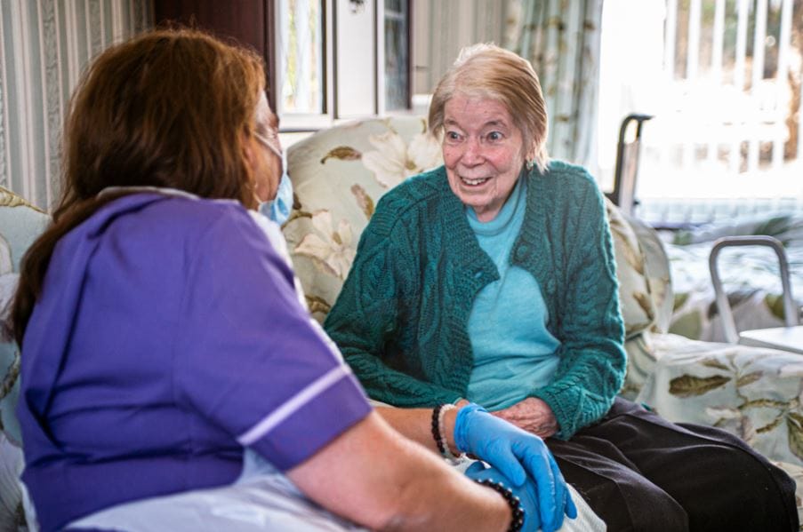 Caregiver interacting with senior resident in a cozy setting