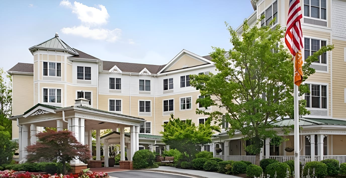 Exterior view of a senior living facility with gardens