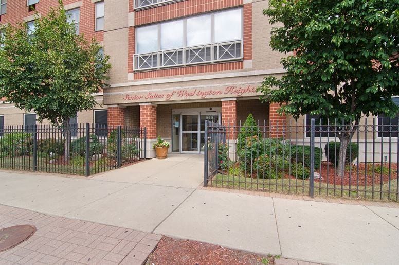 Front entrance of Senior Suites Washington Heights with landscaping