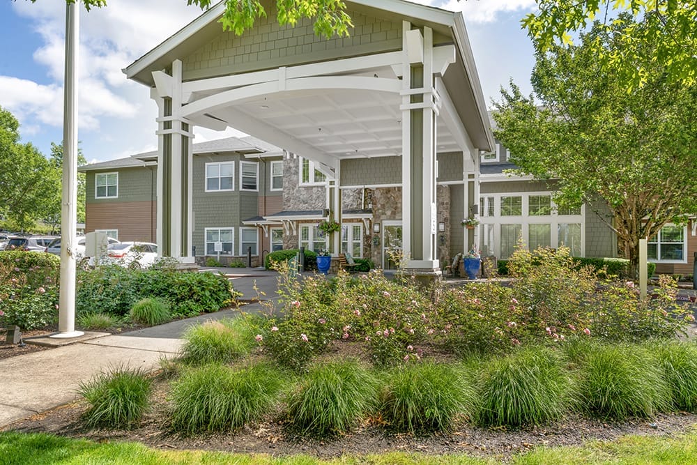 Entrance of Brookdale Newberg with landscaping and a covered area