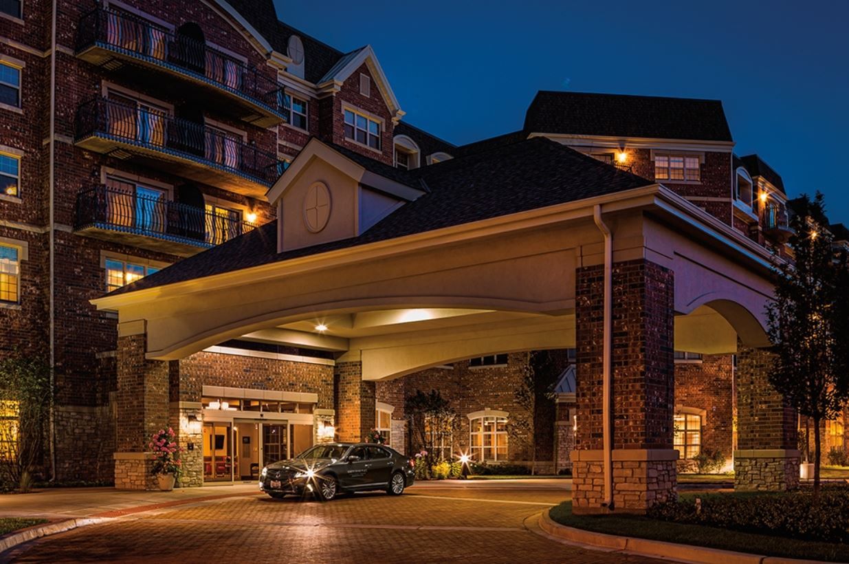 Front entrance of North Shore Place at night with a car