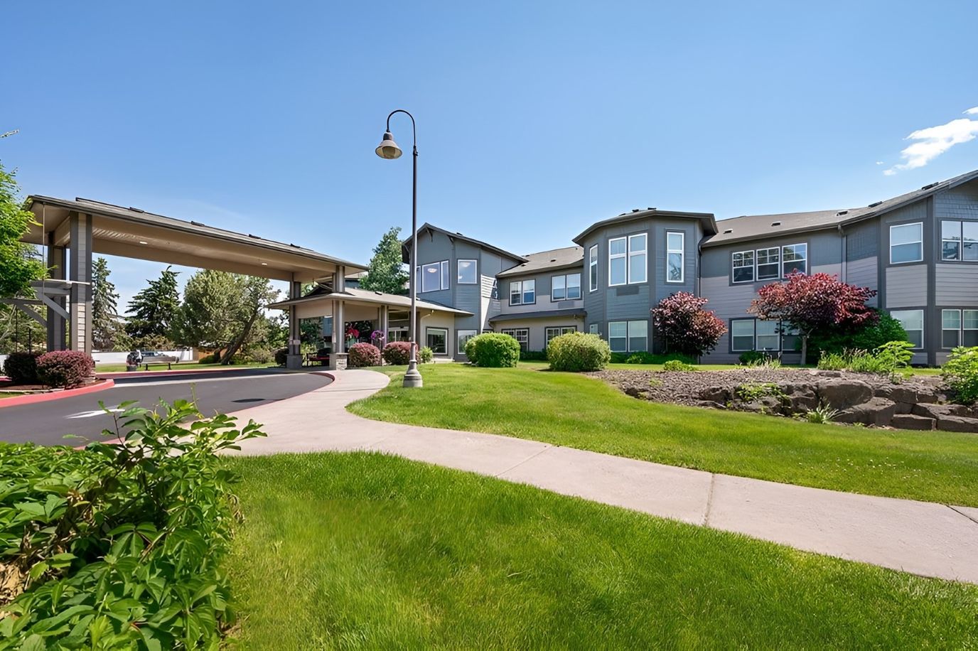Exterior view of a senior living facility with garden areas