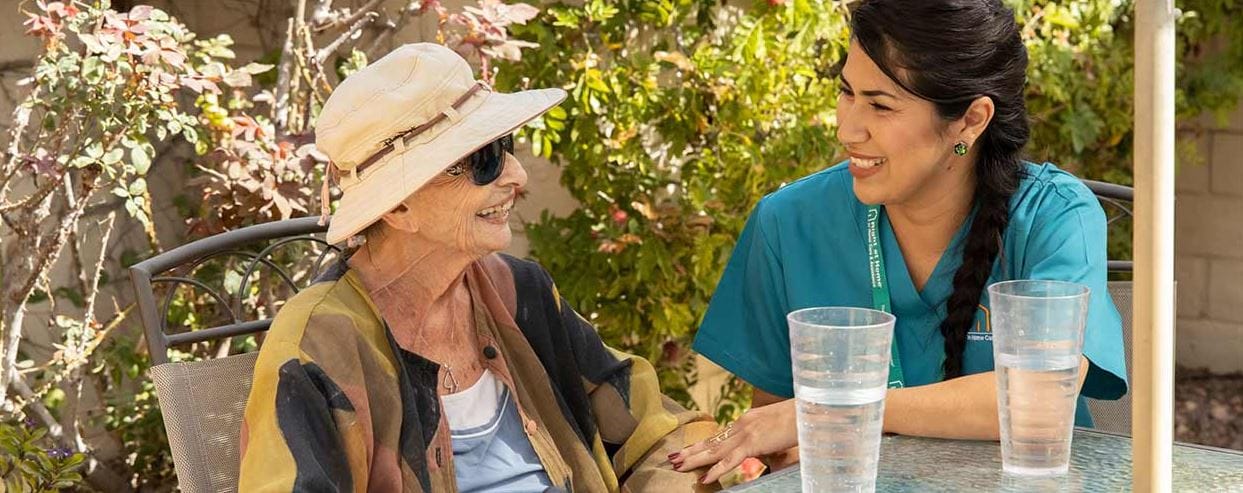A caregiver interacting with a happy resident outdoors