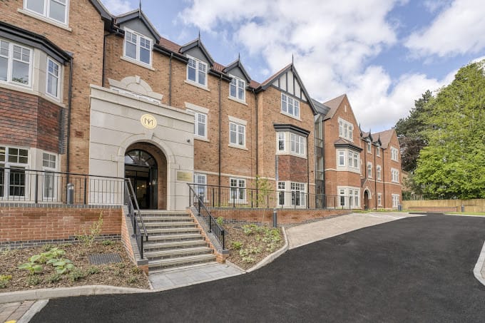 Exterior view of a senior living facility with landscaped entrance