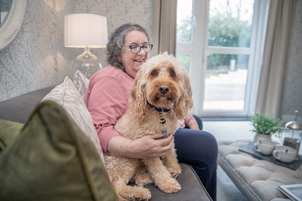 Resident enjoying time with a dog in a common area.