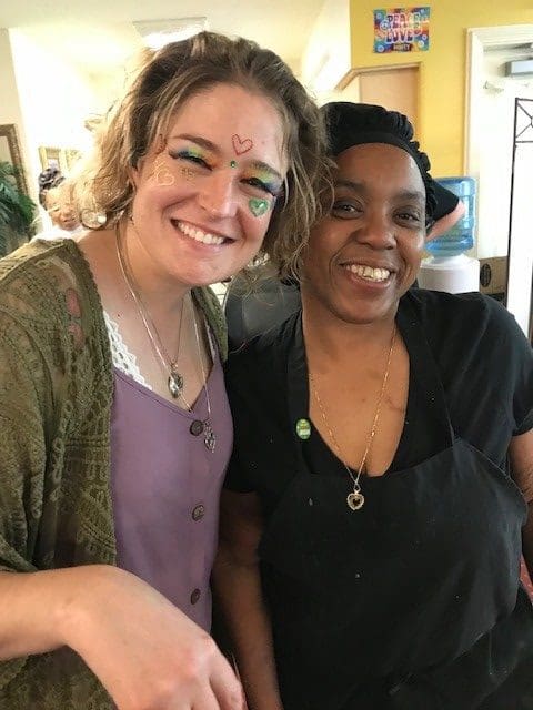 Two staff members smiling together in a vibrant activity space