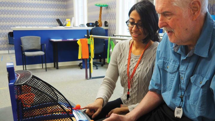 A resident and staff member engaging in a therapeutic activity
