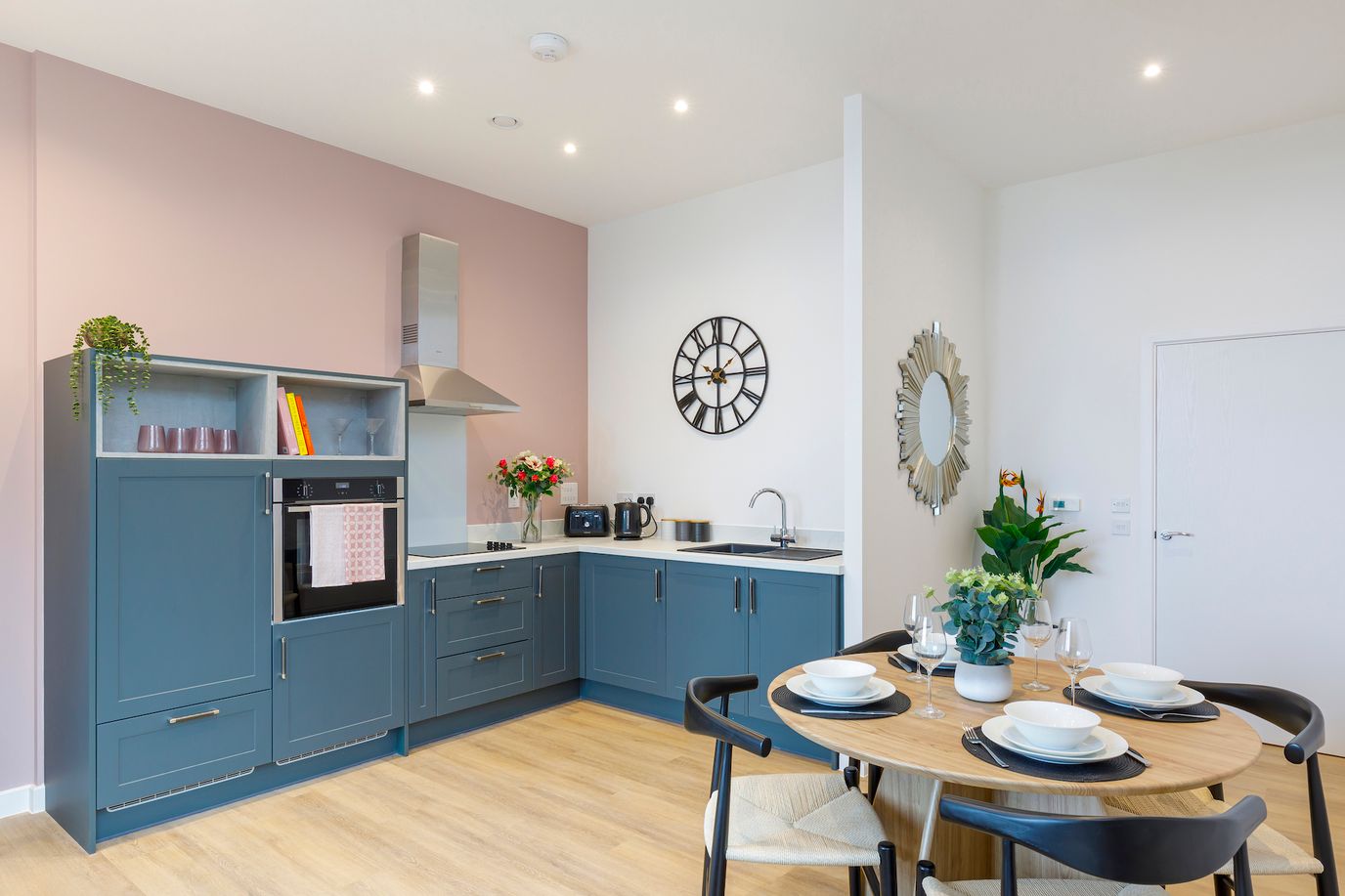 Bright kitchen area with dining table set for residents