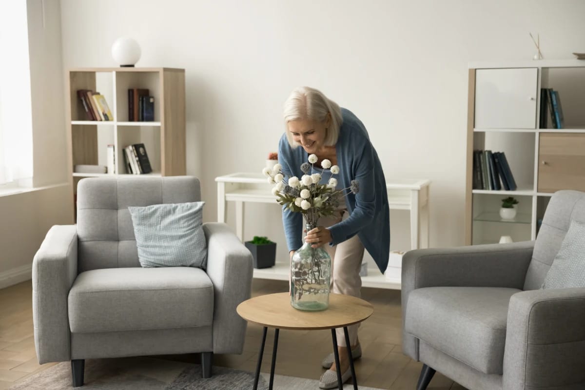 Resident arranging flowers in a cozy common area.
