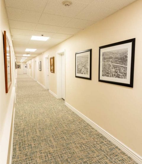 A well-lit hallway with artwork on the walls