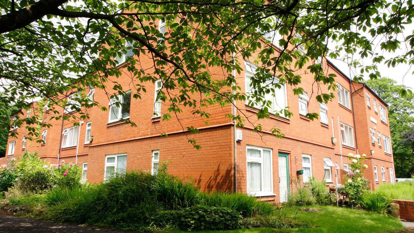 Exterior view of a residential facility surrounded by greenery