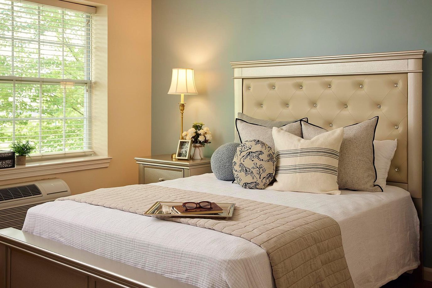 Cozy bedroom setup with decorative pillows and lamp