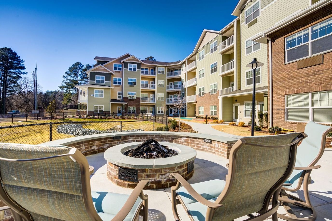 View of an outdoor seating area with a fire pit and building