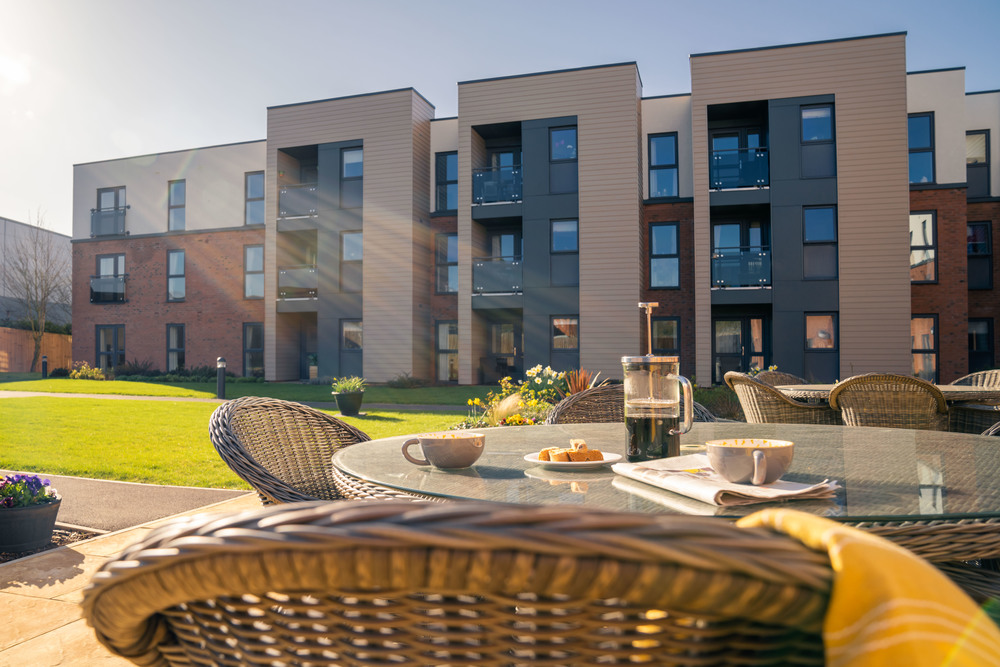 Outdoor seating area with breakfast items and the building behind.