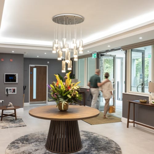Stylish lobby with floral arrangement and residents entering