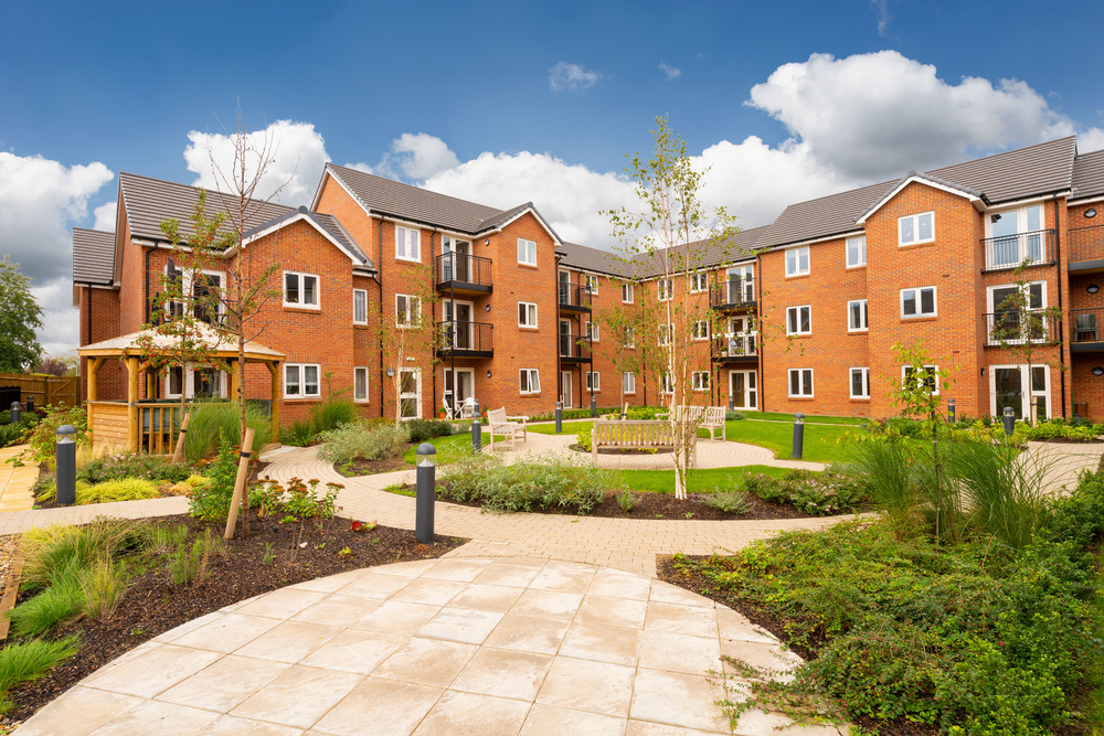 Bright outdoor courtyard with greenery and building facade