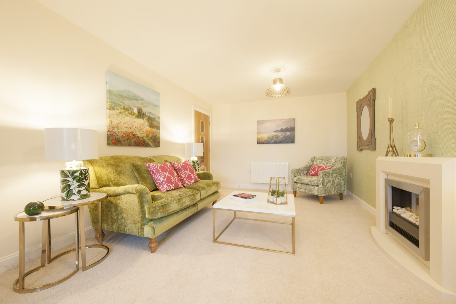 Cozy living room with green sofas and artwork