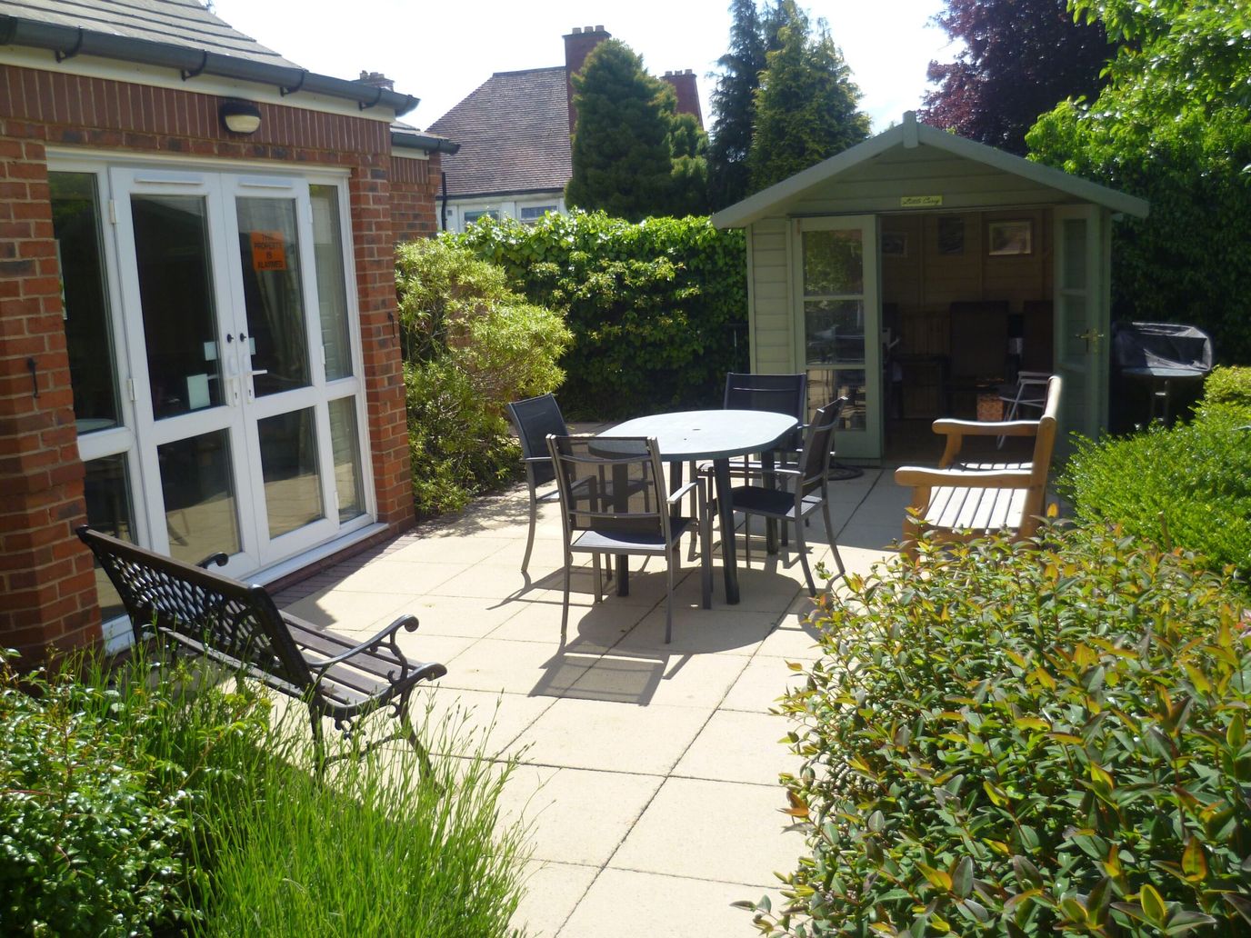 Pilgrim Gardens, independent living in Leicester, UK — Garden patio with chairs and a gazebo
