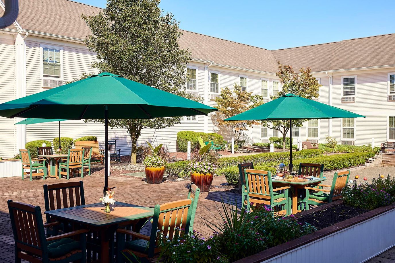 Outdoor patio area with green umbrellas and seating