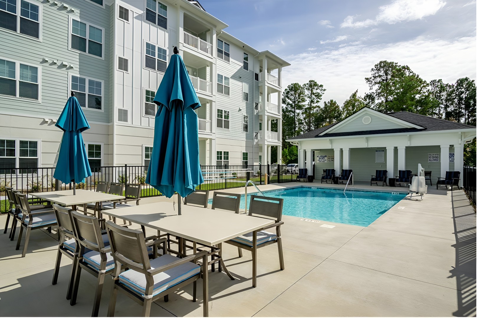 Swimming pool area with seating and umbrellas