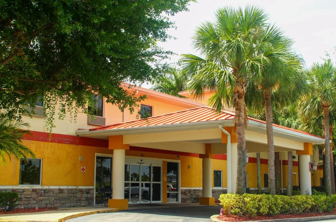 Exterior view of Balmoral Assisted Living facility with palm trees