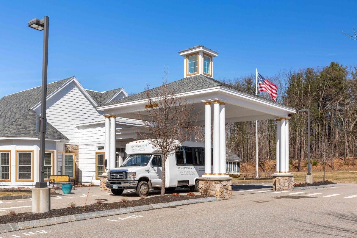 Front entrance of an assisted living facility with a shuttle bus