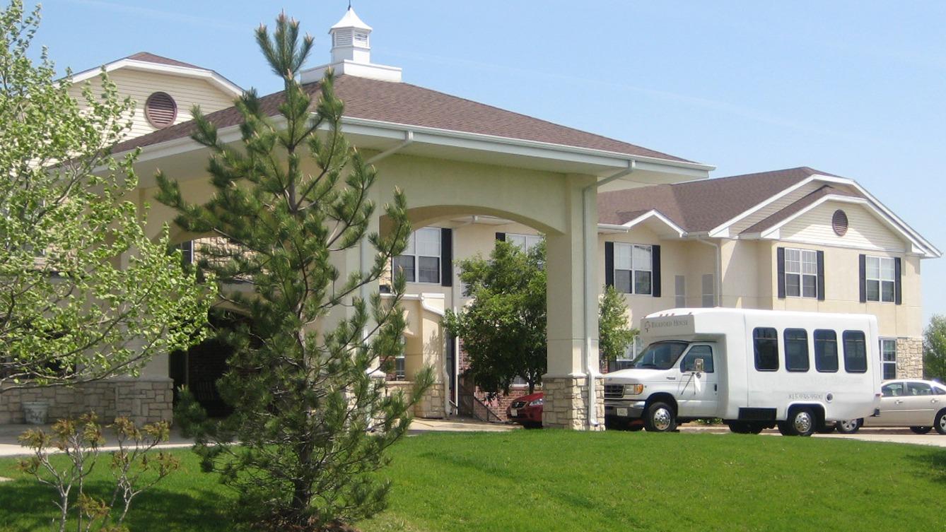 Exterior view of assisted living facility with transport van
