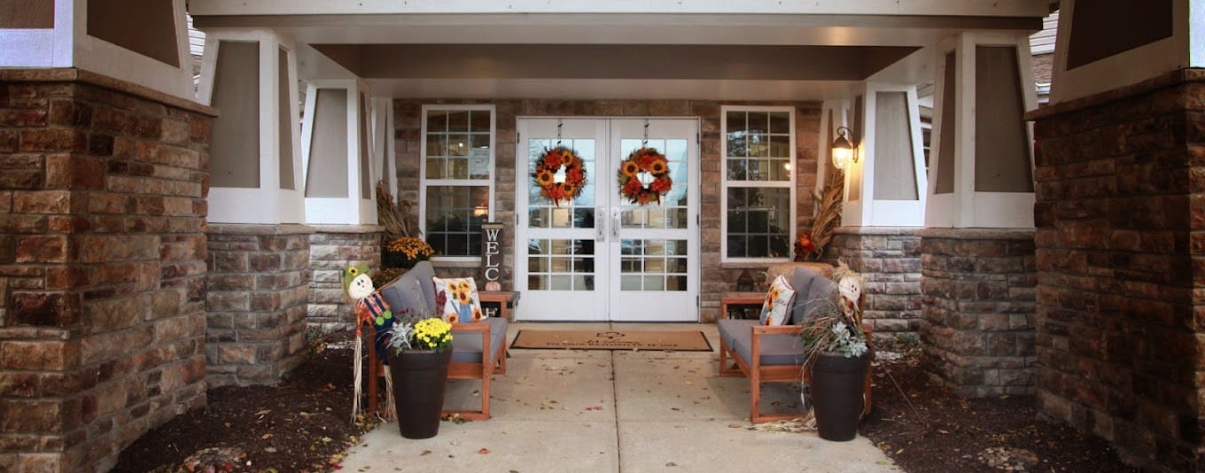 Welcoming entrance of a senior living facility decorated for fall