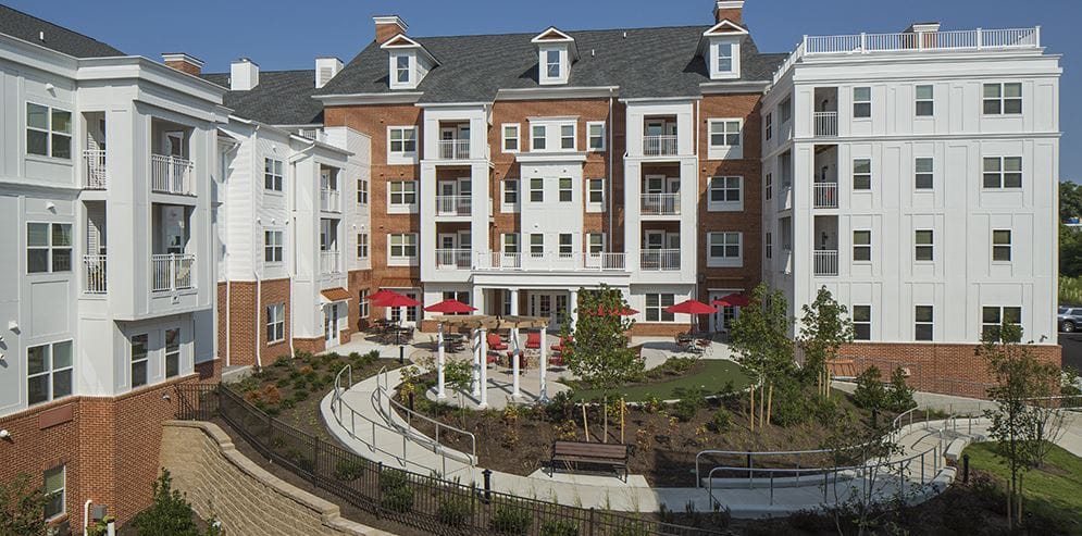 Exterior view of a senior living facility with outdoor seating