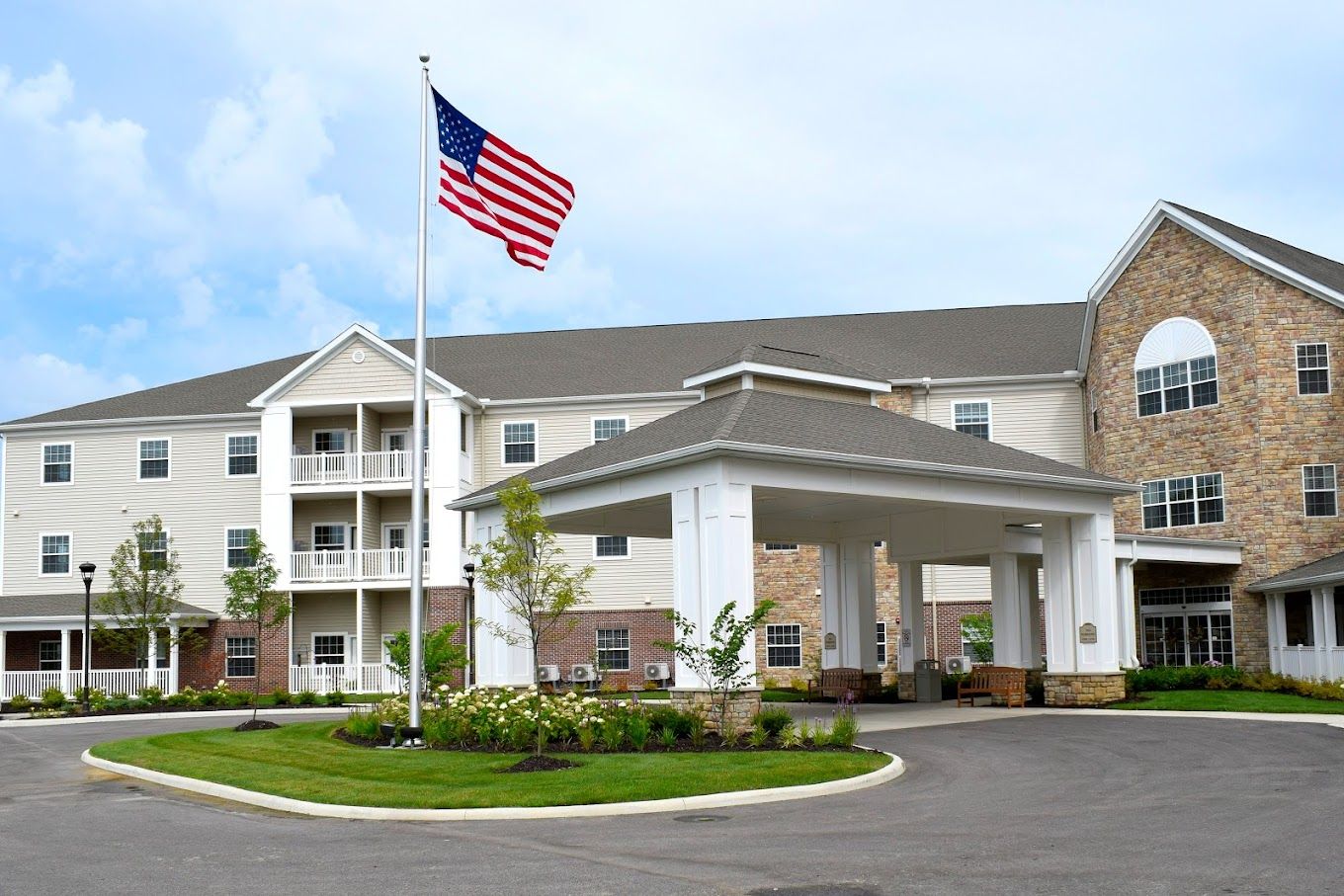 Front view of a senior living facility with flag