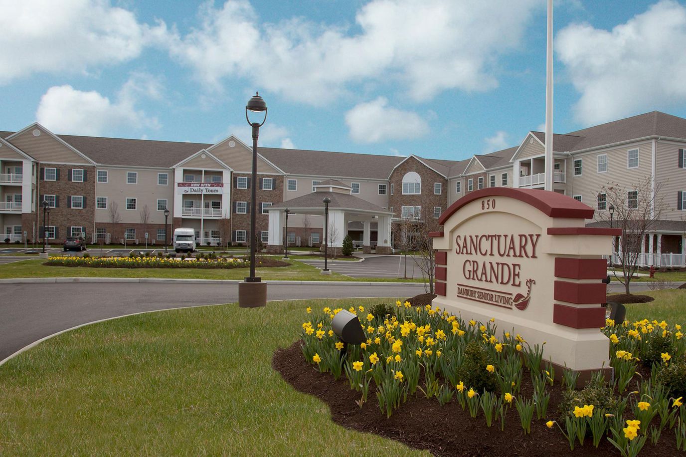 Exterior view of Sanctuary Grande with flowers and signage