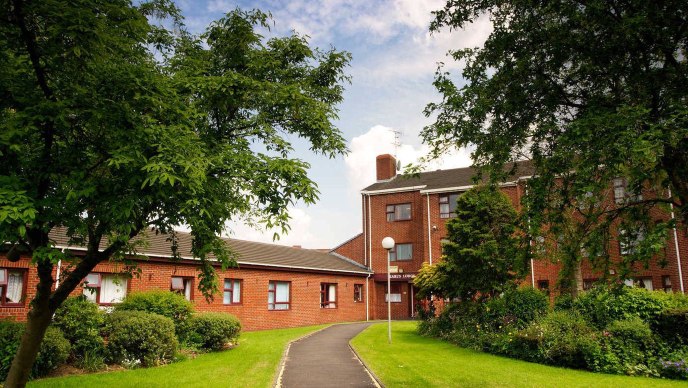 Exterior view of Earls Lodge with landscaping and walkways