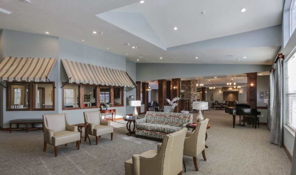 Spacious living room with armchairs and a floral sofa at Heritage Hill Assisted Living.
