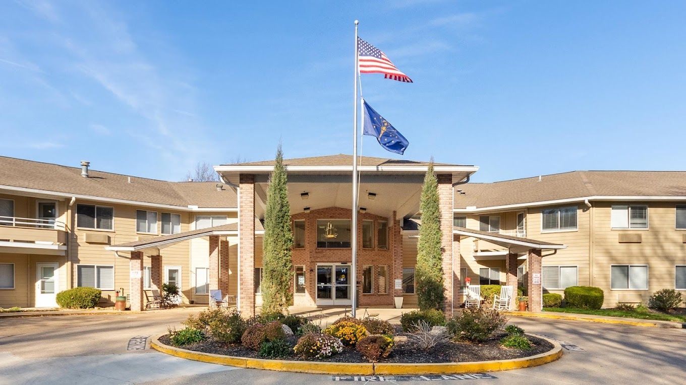 Front entrance of Independence Village with flags and landscaping