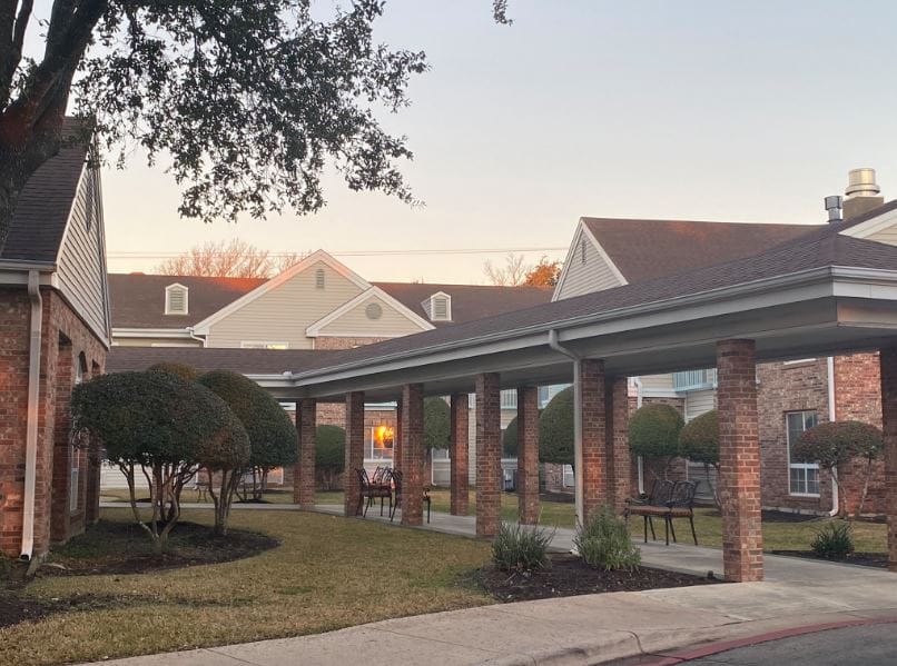 Outdoor area with covered walkway and manicured bushes