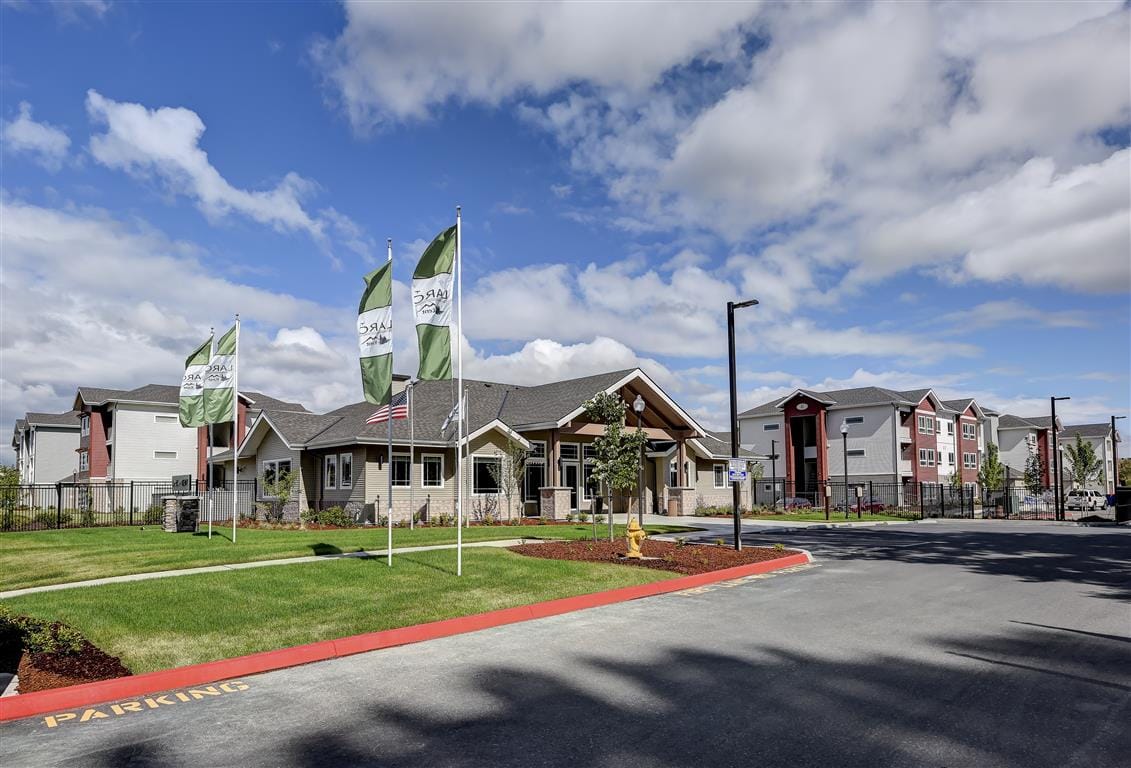 Exterior view of a senior living facility with flags and landscaping