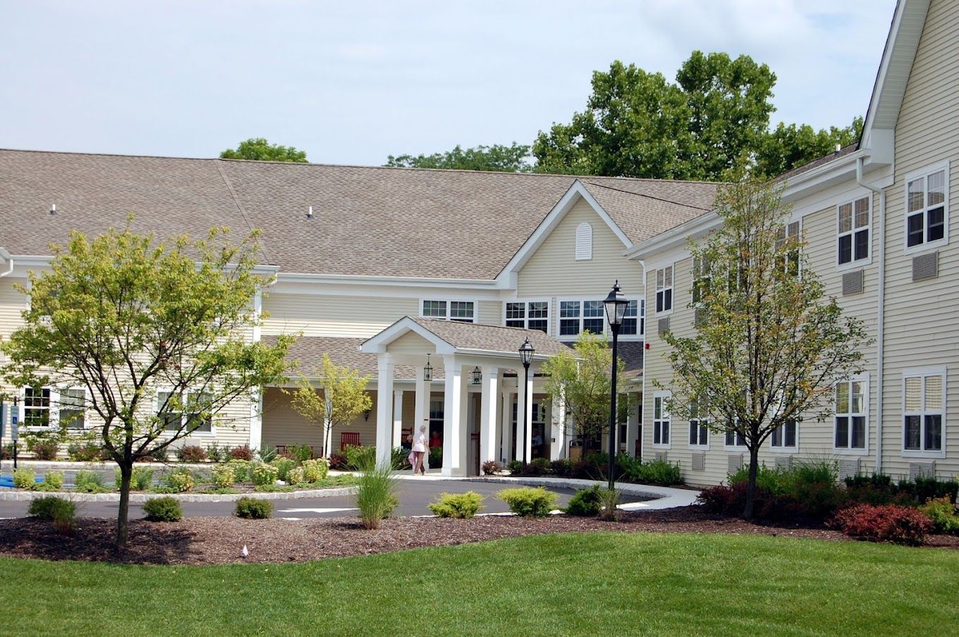 Exterior view of a senior living facility with gardens