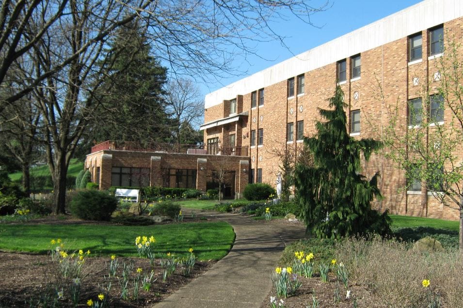 Exterior view of a senior living facility with gardens