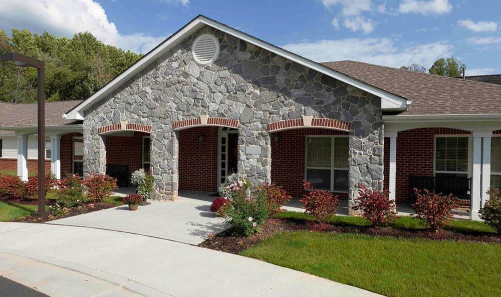 Exterior view of Olney Assisted Living facility with landscaped entrance
