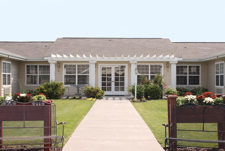 Front entrance of Pomerelle Place Senior Living with landscaped path